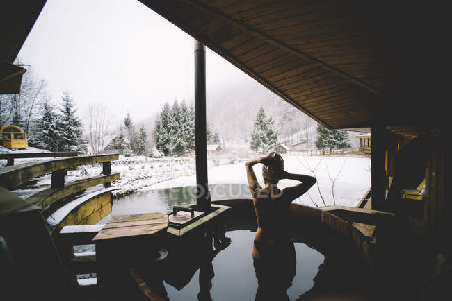 Красивая девушка в термальных ваннах снежный пейзаж. — стоковое фото