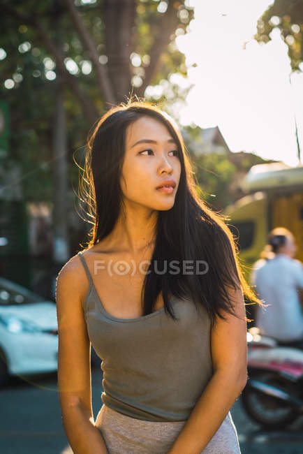 Serena mulher posando na rua e olhando para longe — Fotografia de Stock