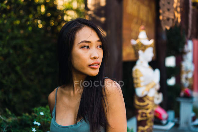 Молода жінка позує на вулиці і дивиться в сторону — стокове фото