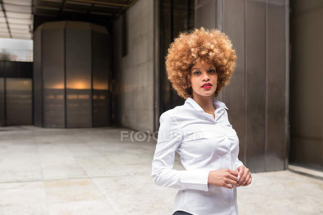 Selbstbewusste Frau im Knopfleibchen-Hemd blickt in die Kamera — Stockfoto
