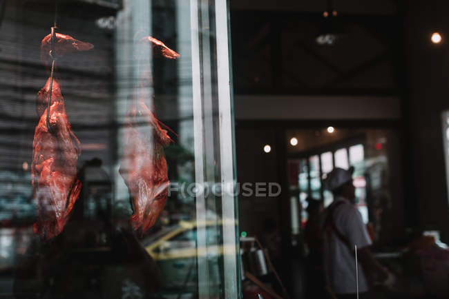 Smoked and prepared ducks hanging in case of Asian restaurant. — Stock Photo