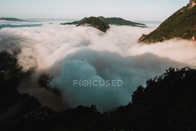 Vista aérea de nuvens flutuando perto de picos de montanha — Fotografia de Stock
