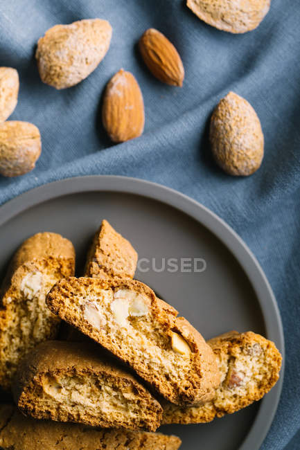 Vue du dessus des biscuits cantuccini sur assiette et amande — Photo de stock