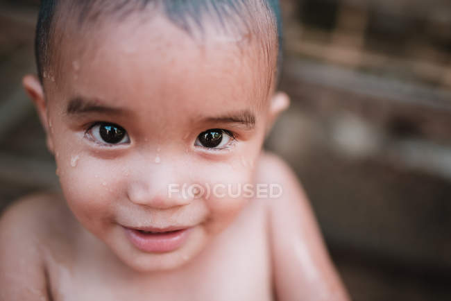 Nong Khiaw, Лаос: Симпатичний хлопчик з мокрим обличчя, посміхаючись і, дивлячись на камеру — стокове фото