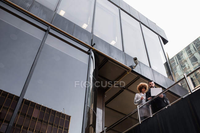 From below couple standing at terrace  and using laptop — Stock Photo