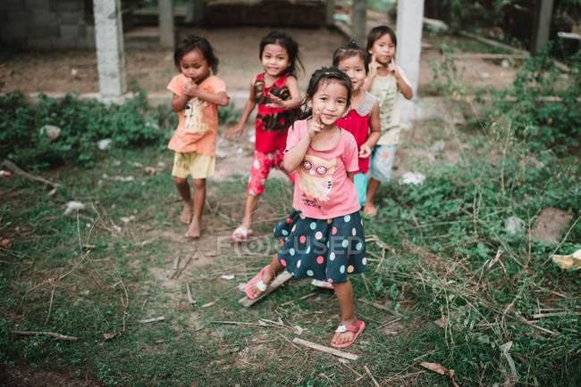 LAOS, 4000 ISLAS ÁREA: Niños alegres posando para la cámara en la calle del pueblo - foto de stock