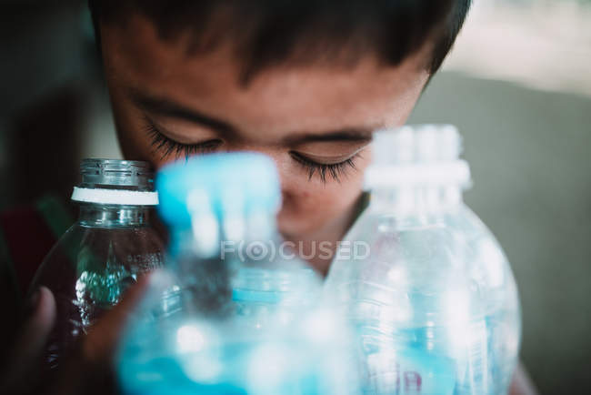 LAOS, 4000 ÎLES : Petit garçon avec des bouteilles en plastique — Photo de stock