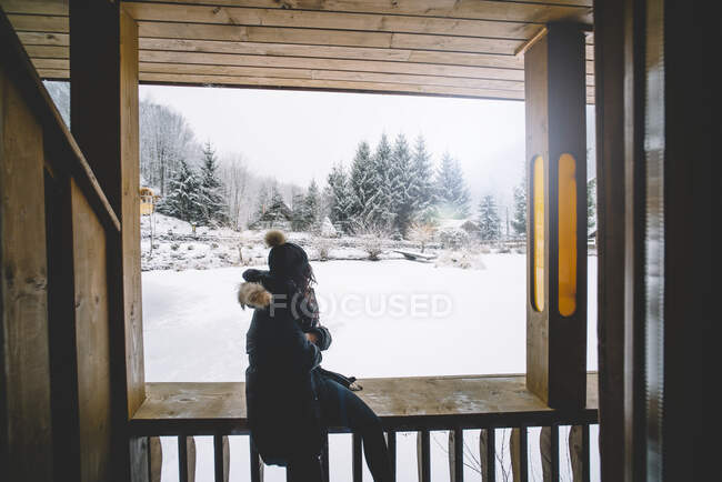 Красивая девушка в окне каюты смотрит на снежный пейзаж. — стоковое фото