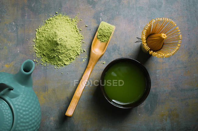 Bamboo scoop and whisk by cup with matcha tea — Stock Photo