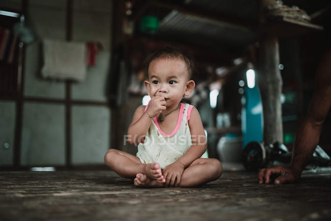 LAOS, 4000 ÎLES : Adorable tout-petit assis sur le sol en bois et mangeant . — Photo de stock