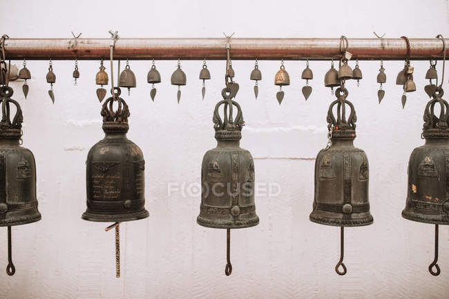 Vista ravvicinata delle campane appese in fila su rack — Foto stock