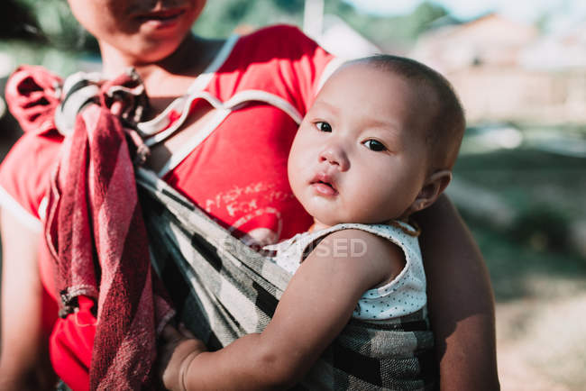 Nong khiaw, laos: Frau trägt niedliches Baby in Narbe — Stockfoto