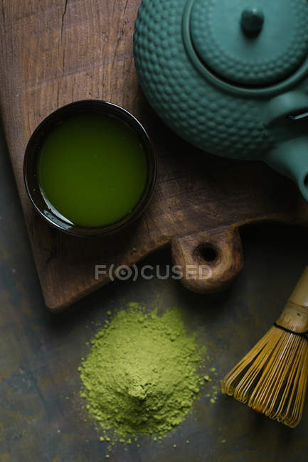 Chá matcha preparado em xícara por panela na placa de corte — Fotografia de Stock