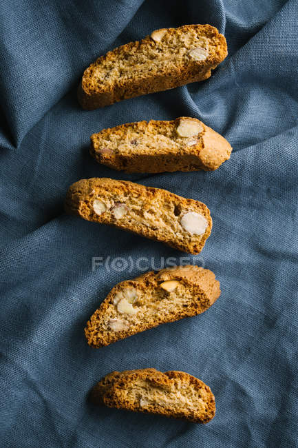 Row of fresh cantuccini biscuits on fabric — Stock Photo