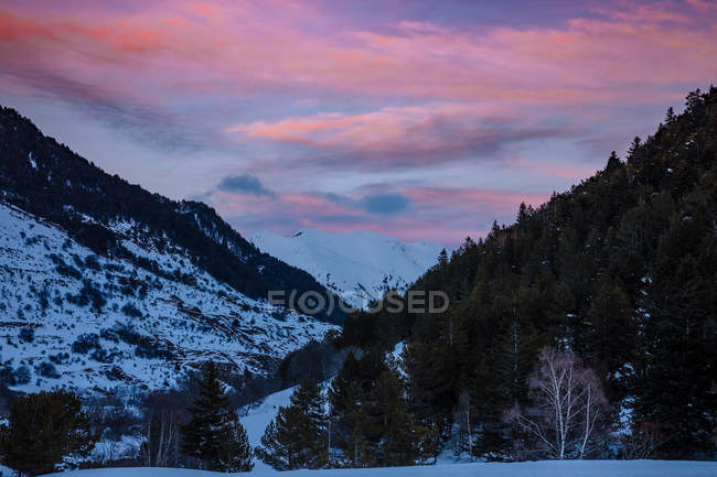 Scenografico tramonto paesaggio nuvoloso sulle montagne innevate — Foto stock
