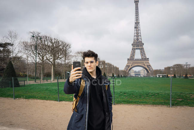 Jovem turista tomando selfie no fundo da Torre Eiffel . — Fotografia de Stock