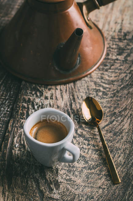 Xícara de café e colher na mesa de madeira rústica — Fotografia de Stock