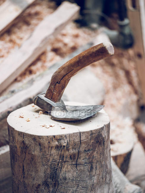 Artisan axe instrument on snag in workshop. — Stock Photo