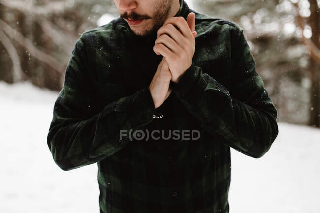 Ernte unkenntlich Touristenmann wärmt Hände und steht im Winter in der Natur. — Stockfoto