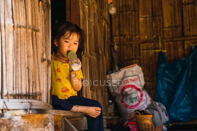 CHIANG RAI, THAILAND- FEVEREIRO 12, 2018: Jovem garota bebendo leite — Fotografia de Stock