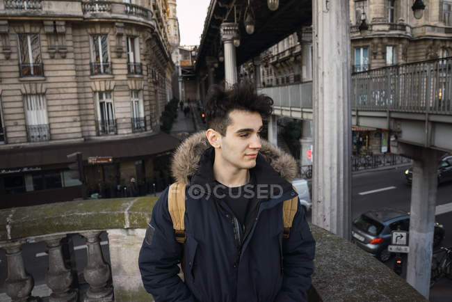 Pensivo jovem turista de pé na passagem escadas e olhando para longe . — Fotografia de Stock