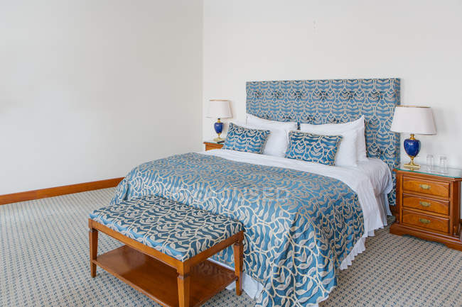 Інтер'єр спальні готелю з біло-блакитним ліжком — стокове фото