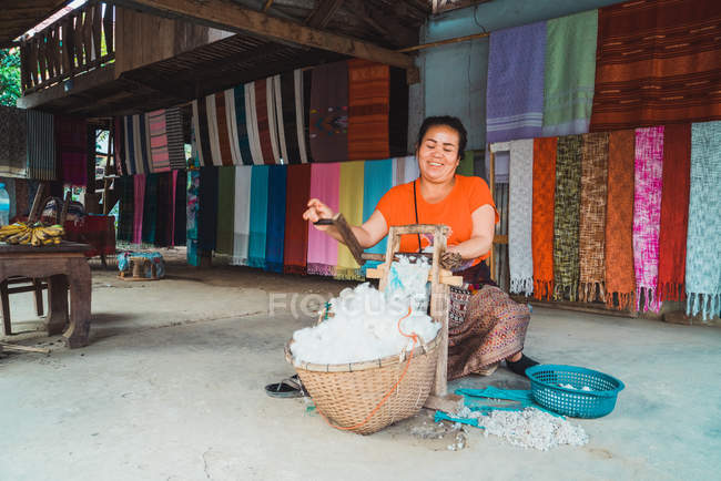 LAOS- FEBRERO 18, 2018: Mujer sonriente produciendo tela - foto de stock