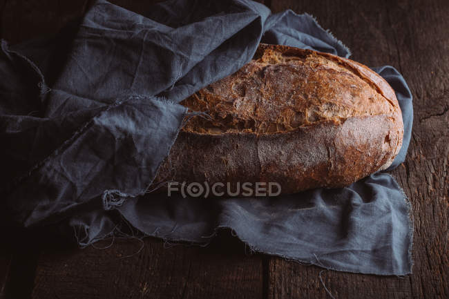 Still life of rustic loaf of artisan bread on dark background — Stock Photo
