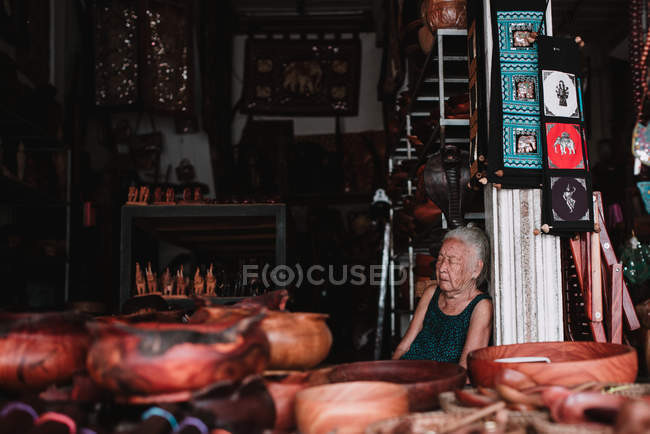LAOS, LUANG PRABANG : Femme âgée dormant au comptoir au marché . — Photo de stock