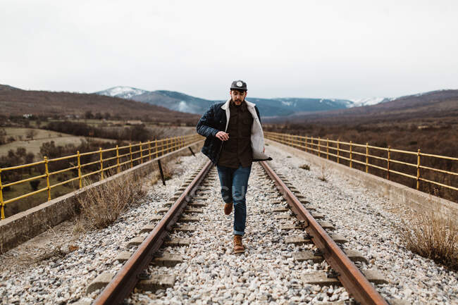Взрослый человек бегает по железной дороге в поле на природе. РЕЛИЗ — стоковое фото