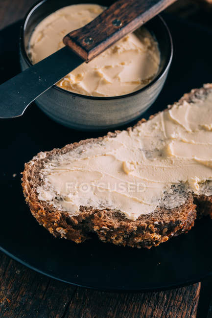 Vista de cerca del pan fresco con mantequilla - foto de stock