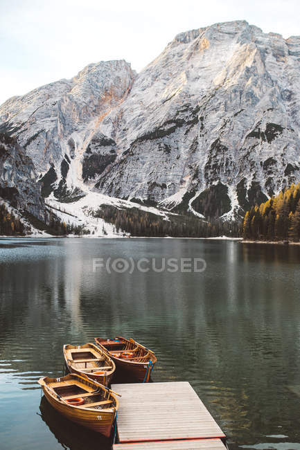 Вид на дерев'яний пірс з причаленими човнами на гірському озері — стокове фото