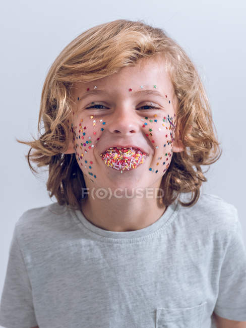 Веселий хлопчик з конфетті на обличчі — стокове фото