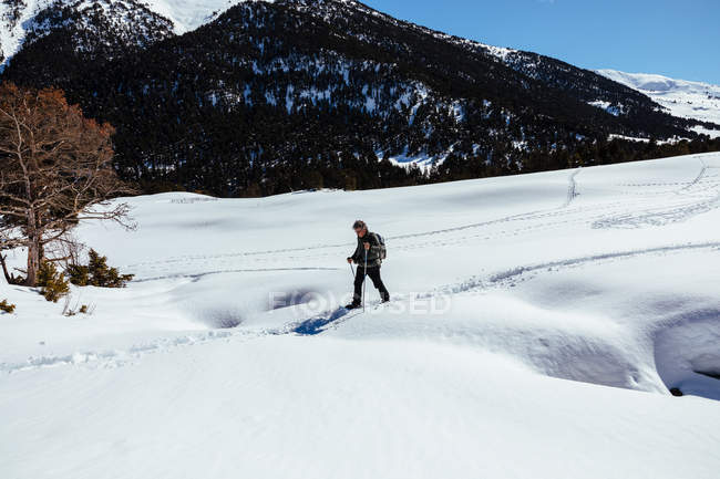 Вид сбоку на человека, идущего по снегу — стоковое фото
