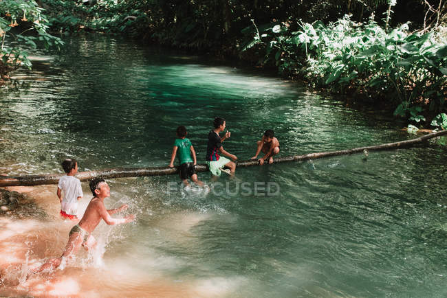 Laos, luang prabang: Kinder schwimmen im See und amüsieren sich auf der Brücke — Stockfoto