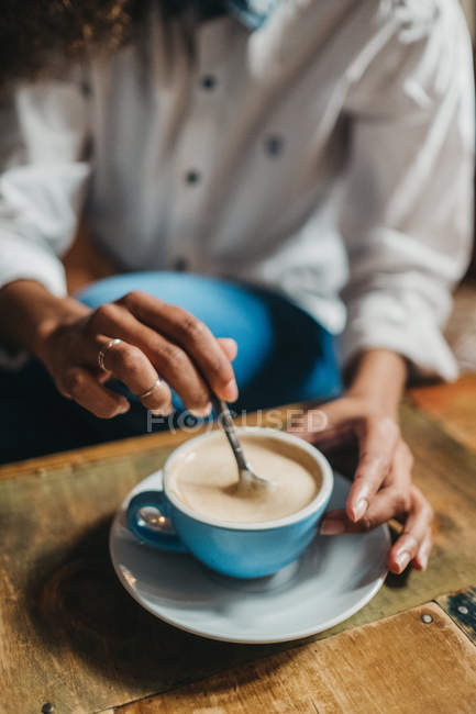 Erntehelferinnen rühren Tasse Kaffee auf Tisch — Stockfoto