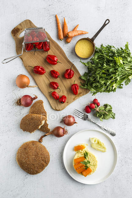 Mesa e tábua de corte com ingredientes para cuscuz — Fotografia de Stock