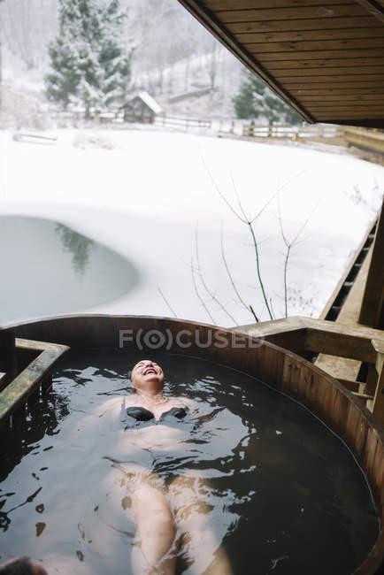 Cheerful woman swimming in outside plunge tub in winter nature. — Stock Photo