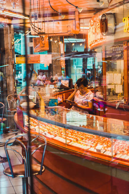 ЧАЙАНГ-РАЙ, ТАЙЛАНД - 25 ЯНВАРЯ 2018 года: Женщина, работающая в ювелирном магазине, сидит на рабочем месте и использует цифровой планшет . — стоковое фото