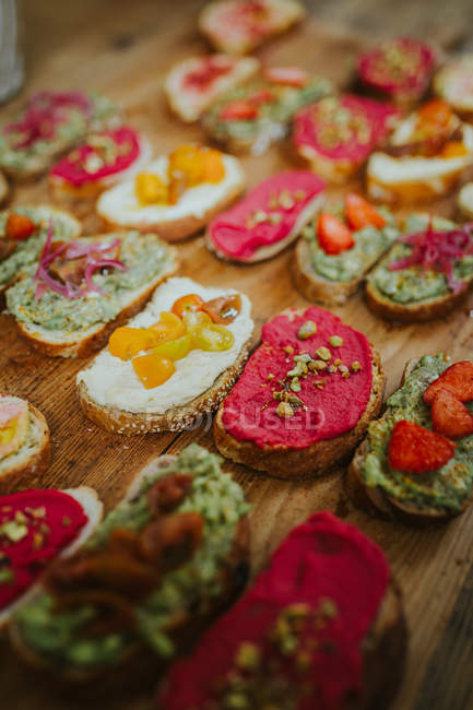 Sandwiches with different toppings served on wooden board. — Stock Photo