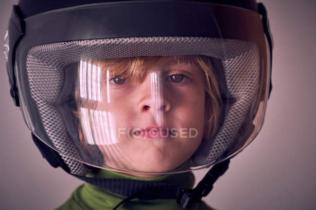 Mignon garçon en casque de moto en regardant la caméra — Photo de stock