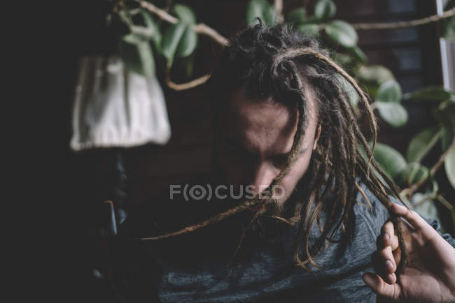 Мужчина дрожит волосами с дредами — стоковое фото