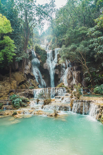 Vista a las cascadas tropicales que fluyen hacia abajo en el lago turquioso - foto de stock