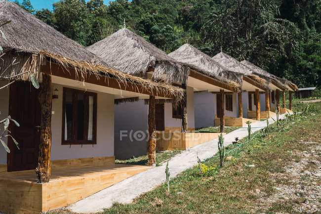 Bonitos pequenos bangalôs com telhado de palha em linha — Fotografia de Stock