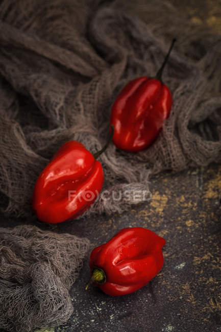 Natura morta di peperoni rossi freschi su tessuto rurale — Foto stock