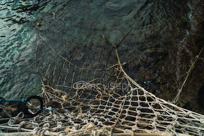 Looking down view of fishing net in ocean waves — Stock Photo