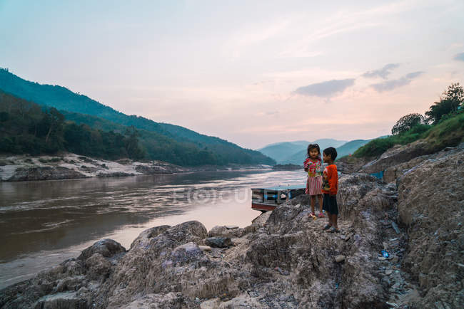Cheerful kids at river landscape in dusk — Stock Photo