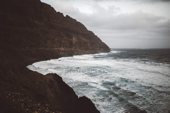 Морський пейзаж хвилястого штормового берега океану в похмурий день . — стокове фото