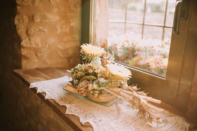 Verschiedene Blumensträuße auf der Fensterbank im Sonnenlicht. — Stockfoto
