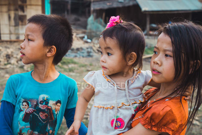 LAOS- FEBRUARY 18, 2018: Young boy and girls standing in village and looking aside. — Stock Photo